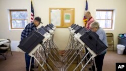 FILE - Voters cast ballots in the primary election in Chesterville, Ohio, March 15, 2016. President Donald Trump made unsubstantiated claims that millions of people voted illegally in the 2016 election.