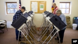 FILE - Voters cast ballots in the primary election in Chesterville, Ohio, March 15, 2016. President Donald Trump made unsubstantiated claims that millions of people voted illegally in the 2016 election.