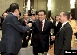 China's Premier Li Keqiang, center, toasts with Kazakhstan's Prime Minister Karim Massimov, left, and Russia's Prime Minister Dmitry Medvedev during a gala ahead of the 14th Shanghai Cooperation Organization Prime Ministers Meeting, in Zhengzhou, Henan province, China, Dec. 14, 2015.