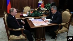 지난달 23일 러시아 모스크바 크렘린 궁에서 블라디미르 푸틴 러시아 대통령(왼쪽)이 세르게이 쇼이구 러시아 국방장관의 보고를 받고 있다.
