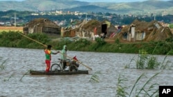 Residents cross flooded fields in Madagascar's capital Antananarivo, on Thursday, March 9, 2017.