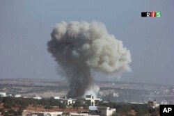 This photo provided by the Revolutionary Forces of Syria, an opposition activist media organization, which has been authenticated based on its contents and other AP reporting, shows an airstrike that killed nearly 30 people in the village of Hass, Syria, Oct. 26, 2016.