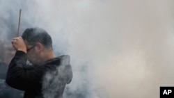 2017年1月1日，北京首都雍和宫喇嘛庙被笼罩在雾霾之中。一名男子在元旦给佛祖上香。