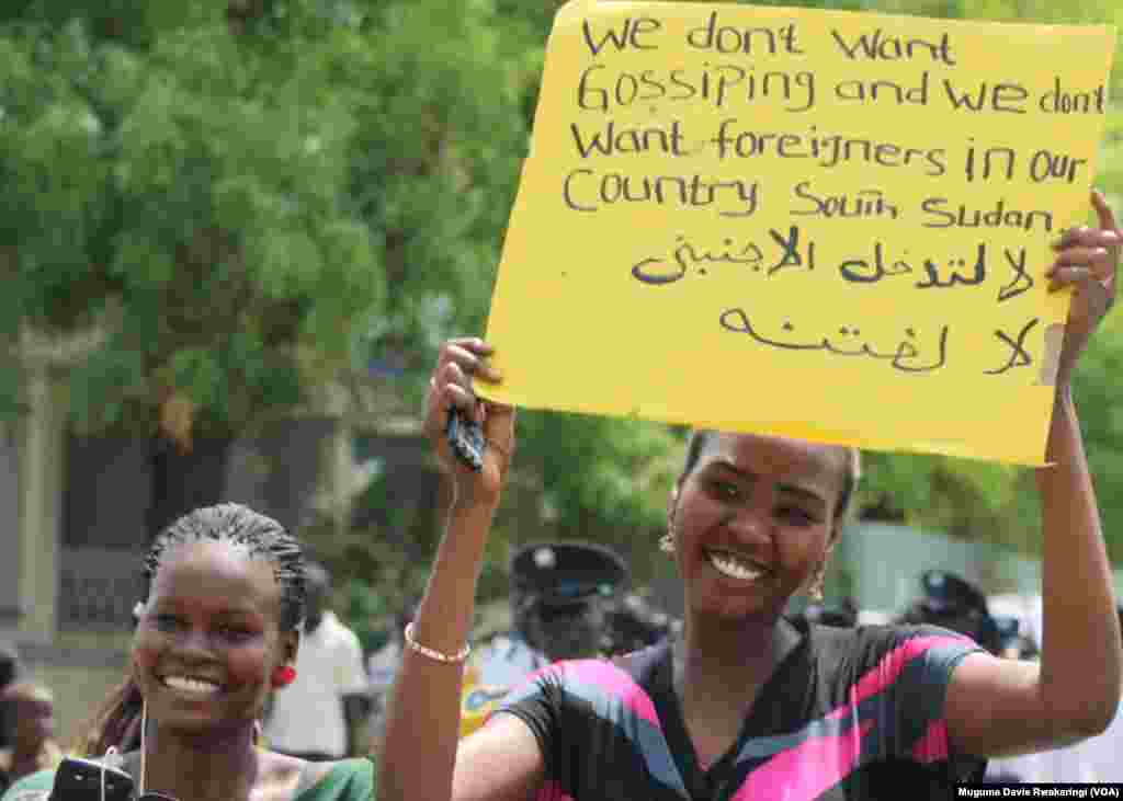 Uma mulher segura um cartaz escrito à mão, dizendo que os sul-sudaneses não querem estrangeiros a governá-los, numa manifestação pacífica, organizada pelo Governo em Juba. Março, 10, 2014.