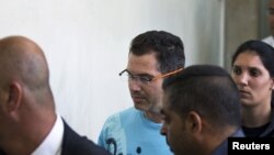 FILE - Ziv Orenstein (C), who is accused by U.S. authorities of engaging in a stock manipulation scheme involving U.S. penny stocks, arrives at a courtroom at the Jerusalem Magistrates Court July 22, 2015. 