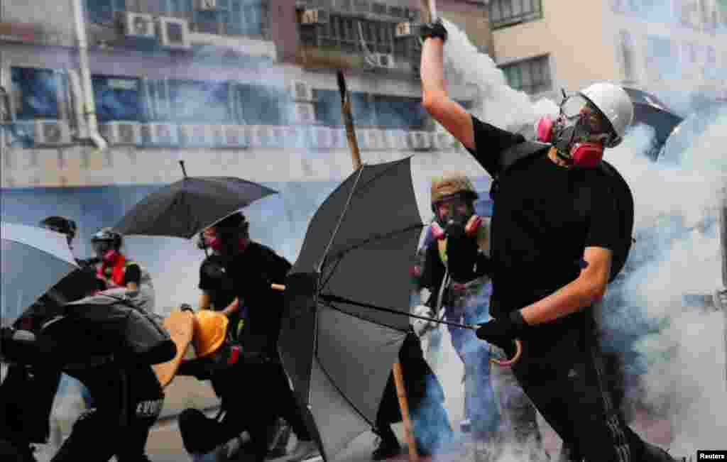 一名香港抗议者星期六（8-24-2019）向警方仍回一枚催泪弹。路透社