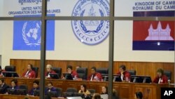 File photo of the Extraordinary Chambers in the Courts of Cambodia, court officers of the U.N.-backed war crimes tribunal are seen through windows during a hearing of former Khmer Rouge top leaders in Phnom Penh, file photo. 