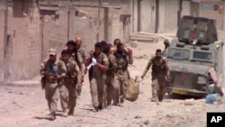 This frame grab from video released July 4, 2017, and provided by Furat FM, a Syrian Kurdish activist-run media group, shows U.S.-backed Syrian Democratic Forces fighters in the eastern side of Raqqa, Syria. The SDF forces have breached the wall around Raqqa's Old City, the U.S. military said.