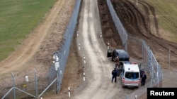 A Hungarian police and soldiers patrol the Hungary-Serbia border, which was recently fortified by a second fence, near the village of Gara, Hungary, March 2, 2017.