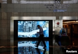 FILE - A man walks past screen at the Indonesia Stock Exchange building in Jakarta, Indonesia, Sept. 6, 2018.