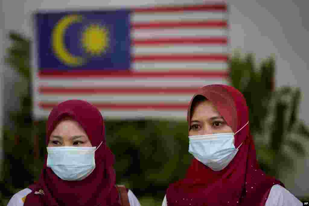 မလေးရှားနိုင်ငံမှာ နှာခေါင်းစည်းတပ် သွားလာနေတဲ့ အမျိုးသမီးအချို့။ (သြဂုတ် ၂၈၊ ၂၀၂၀)