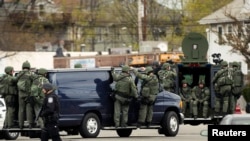 Law enforcement officers in tactical gear during search for Boston bombing suspect Dzhokar Tsarnaev, who was captured in Watertown, Massachusetts, April 19, 2013.