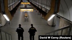 Polisi berpatroli di stasiun kereta bawah tanah yang tampak lengang di tengah karantina wilayah untuk mencegah penyebaran virus corona (COVID-19) di Praha, Ceko, Senin, 1 Maret 2021. (Foto: David W. Cerny/Reuters)