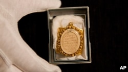 A lock of Wolfgang Amadeus Mozart's hair, contained in a 19th-century gilt locket is posed for photographs at the Sotheby's auction house in London, May 26, 2015. 