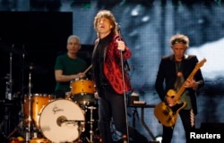 Mick Jagger (C), Charlie Watts (L) and Keith Richards of the Rolling Stones perform during a concert in Abu Dhabi, Feb. 21, 2014.