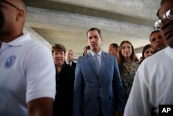 Accompanied by his wife Fabiana Rosales, center right, Venezuela's self proclaimed president Juan Guaido, arrives for a meet with university students at the Central University of Venezuela, in Caracas, Venezuela, Friday, Feb. 9, 2019.