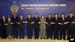 ASEAN foreign ministers and their representatives hold hands during a group photo session of the ASEAN Foreign Ministers Meeting at Bali, Indonesia, November 15, 2011.