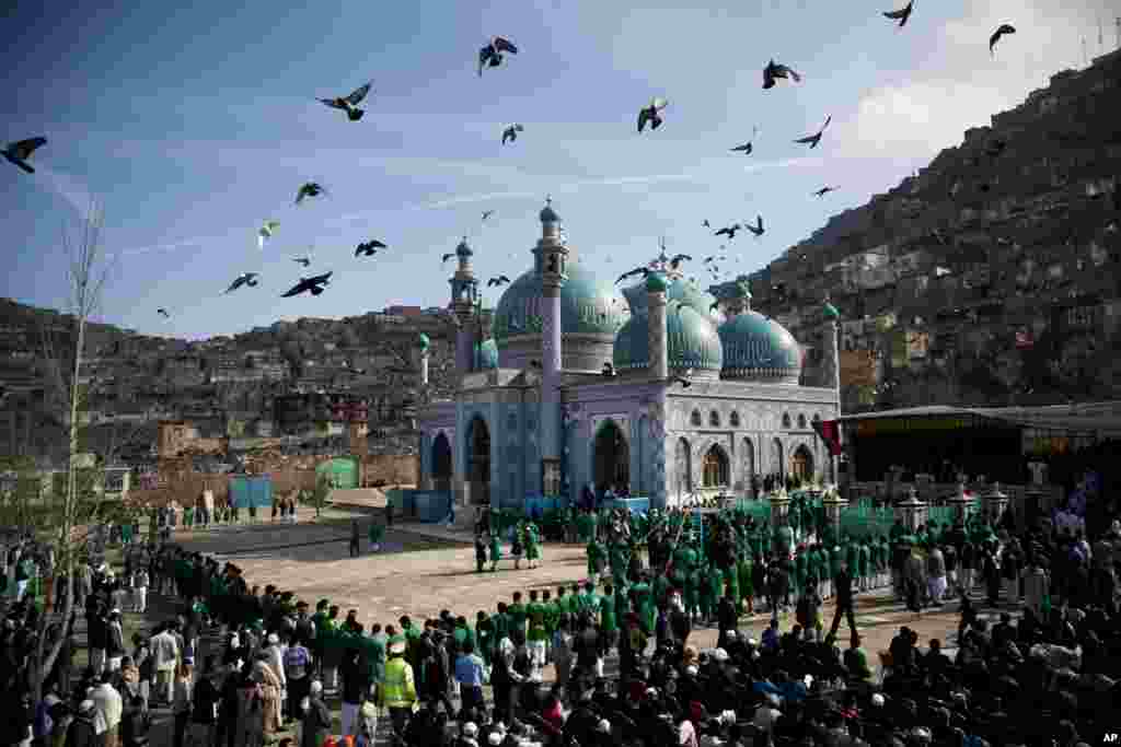 Ribuan warga Afghanistan menunggu untuk melihat bendera suci di masjid Kart-e Sakhi di Kabul. Warga Afghanistan merayakan Nowruz, menandai hari pertama musim semi dan awal tahun pada kalender Iran.