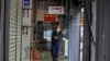 ရန်ကုန်မြို့ Scott ဈေးမှာ ပိတ်ထားရတဲ့ ဆိုင်တွေအနီး ပိုးသတ်ဆေးဖျန်းနေတဲ့ ဝန်ထမ်း တဦး (မတ် ၃၀၊ ၂၀၂၀)