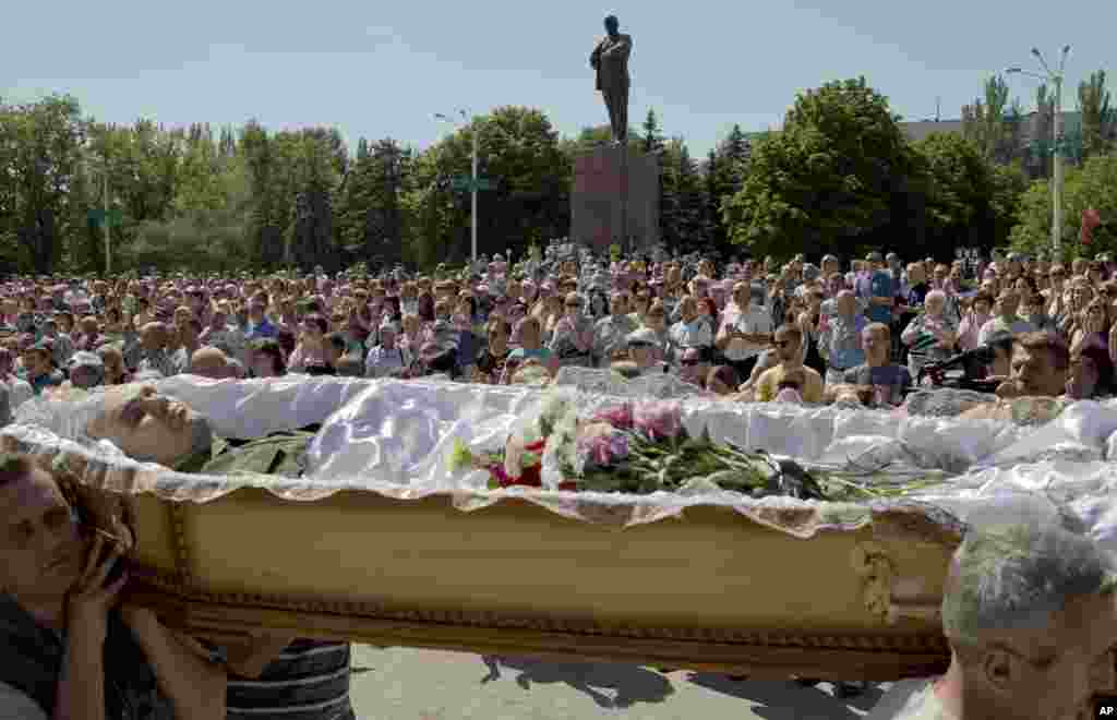 Pallbearers carry the coffin of a pro-Russian insurgent during a funeral for him and four other people, attended by thousands, Stakhanov, eastern Ukraine, May 24, 2014.