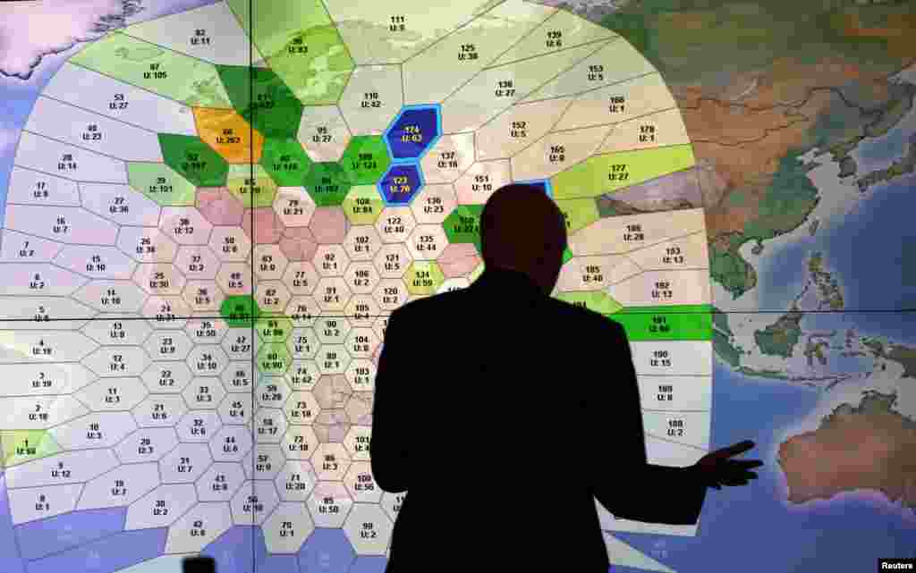 A member of staff at satellite communications company Inmarsat works in front of a screen showing subscribers using their service throughout the world, at their headquarters in London. Britain&#39;s Inmarsat used a wave phenomenon discovered in the nineteenth century to analyze the seven pings its satellite picked up from Malaysia Airlines Flight MH370 to determine its final destination.