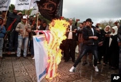 Palestinian demonstrators burn representations of Israeli and American flags during a protest against the possible U.S. decision to recognize Jerusalem as Israel's capital, in Gaza City, Dec. 6, 2017.