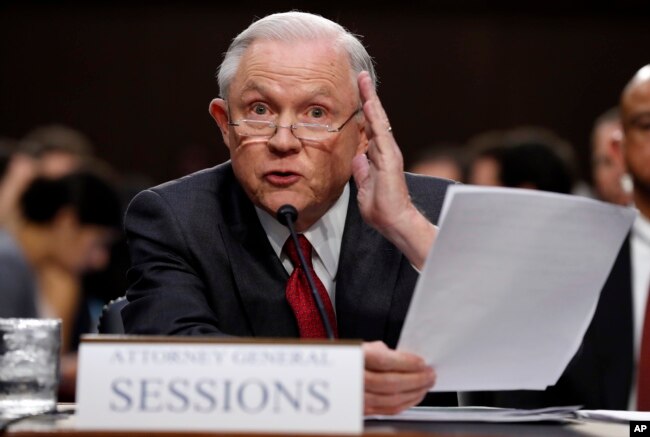 FILE - Attorney General Jeff Sessions reads from a statute about his recusal from the Russia probe while testifying on Capitol Hill in Washington, June 13, 2017, before a Senate Intelligence Committee hearing.