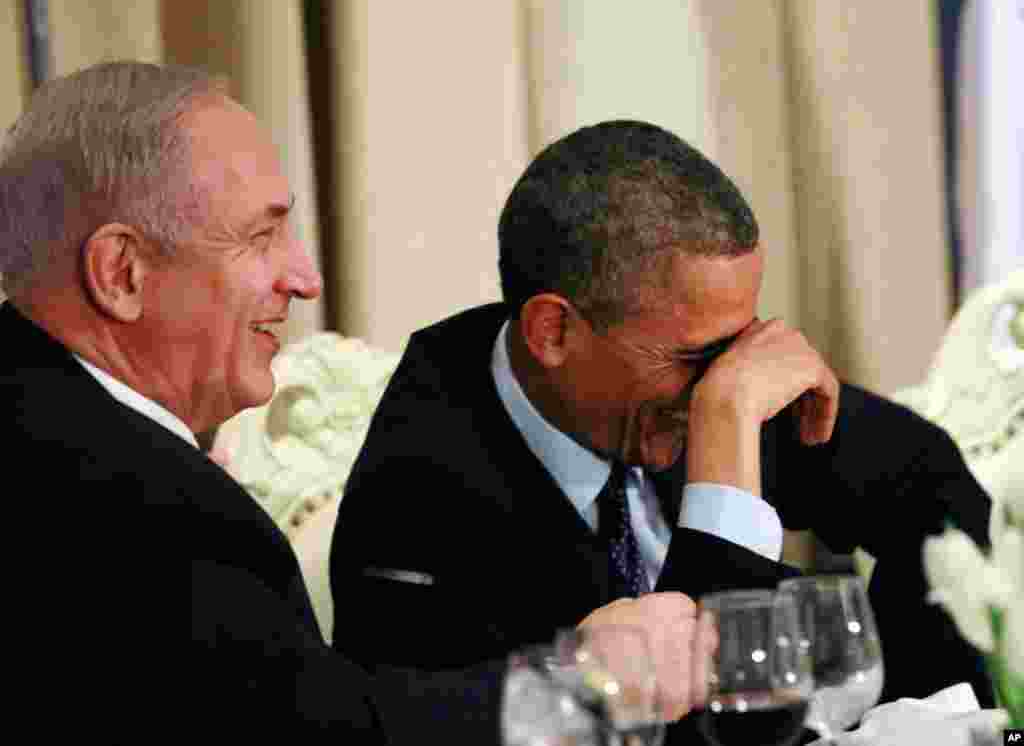 Obama shares a laugh with Israel's Prime Minister Benjamin Netanyahu, during an official state dinner hosted by Israel's President Shimon Peres (not pictured) in Jerusalem, March 21, 2013.