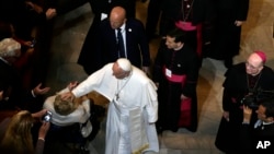 Pope Francis touches a woman in a wheelchair after he addressed a gathering in Saint Martin's Chapel at St. Charles Borromeo Seminary in Wynnewood, Pa., Sept. 27, 2015.
