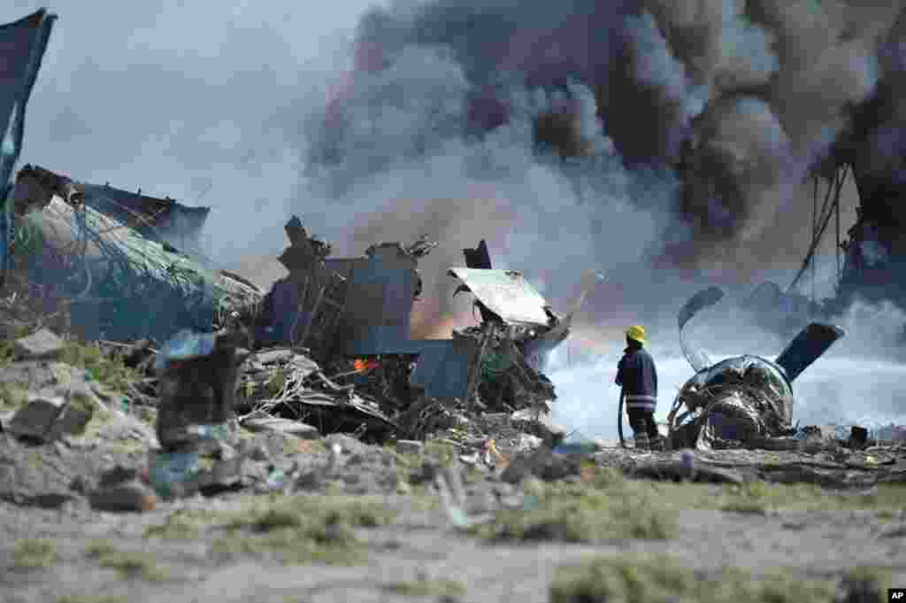 Firefighters attempt to extinguish the fire at Mogadishu&#39;s Aden Adde International Airport in Somalia after an Ethiopian Air Force aircraft crashed upon landing. (Photo provided by AMISOM)