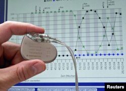 A pacemaker is shown against the backdrop of a cardiological graph in Potsdam, Germany, Feb. 26, 2004