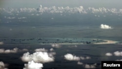 FILE - An aerial photo taken though the window of a Philippine military plane shows the land reclamation by China on Mischief Reef in the Spratly Islands in the South China Sea, west of Palawan, Philippines, May 11, 2015.