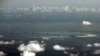 FILE - An aerial photo taken though the window of a Philippine military plane shows the land reclamation by China in the Spratly Islands in the South China Sea, west of Palawan, Philippines, May 11, 2015.