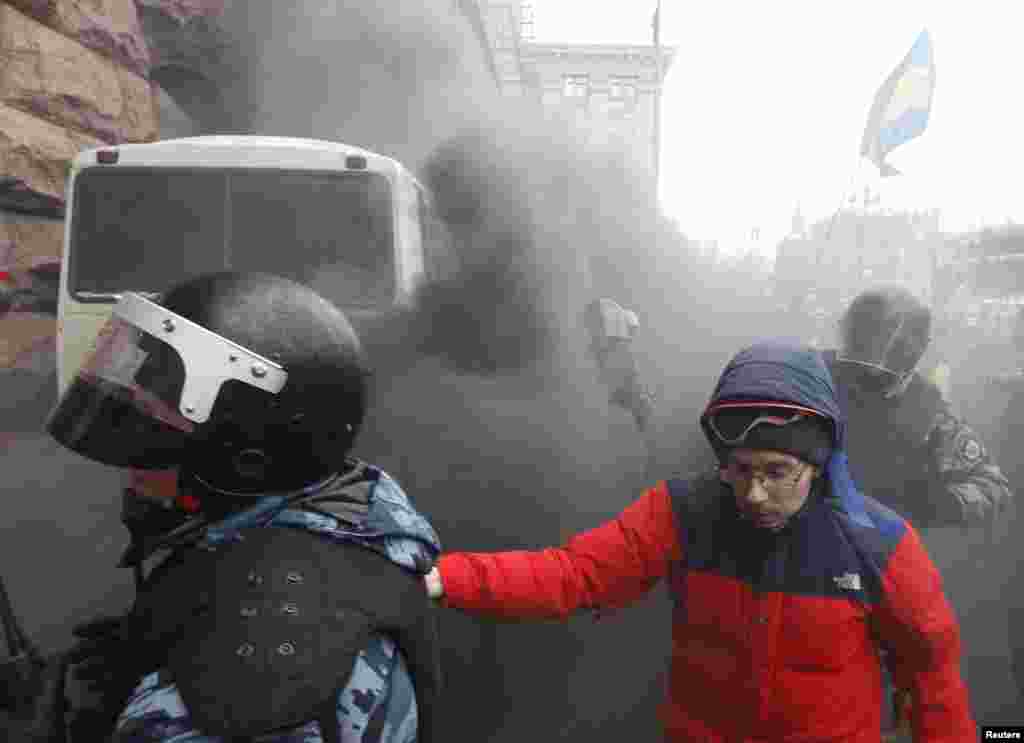 Riot police leave a bus after protesters threw a smoke bomb, outside City Hall in Kyiv, Dec. 11, 2013. 