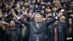 Ukrainian President Petro Poroshenko (C) gestures in front of supporters as he waits for presidential candidate Volodymyr Zelensky for a debate before a high-stakes run-off vote at Olympiysky Stadium in Kyiv on April 14, 2019. 