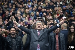 Ukrainian President Petro Poroshenko (C) gestures in front of his supporters as he waits for presidential candidate Volodymyr Zelensky for a debate before a high-stakes run-off vote at Olympiysky Stadium in Kyiv, April 14, 2019.