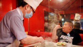 Kyuta Kumagai, 10, eats steak, which his father bought him as a reward after training, at 'Chime', a restaurant in Tokyo, Japan, August 21, 2020. On an average day, Kyuta will consume 2,700 to 4,000 calories. (REUTERS/Kim Kyung-Hoon)
