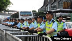 香港警察在铁马以及水马路障后面严阵以待