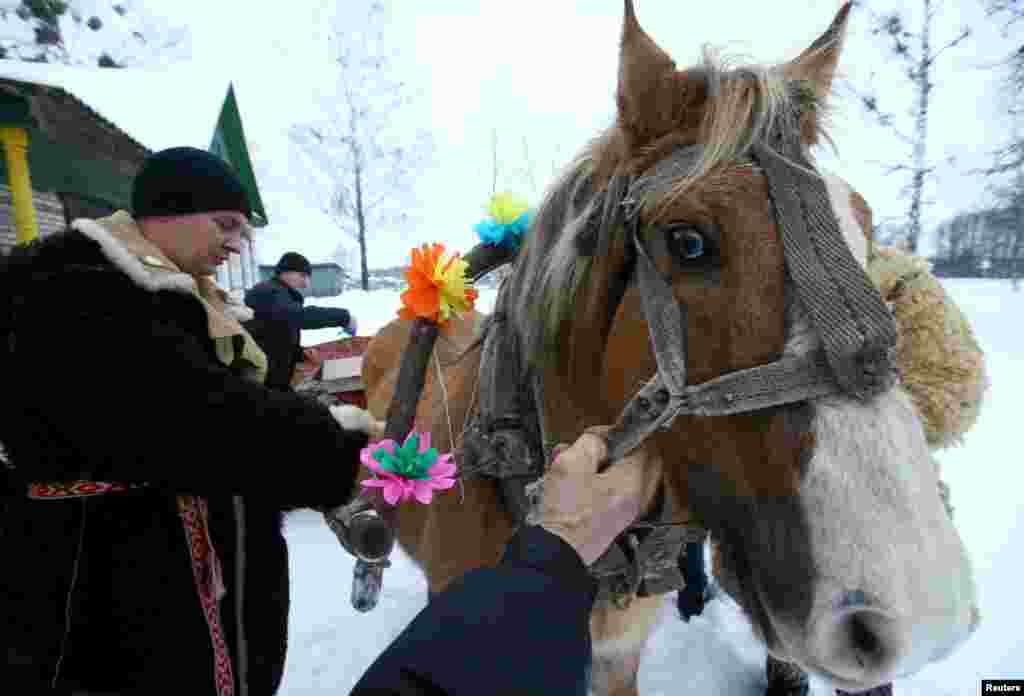 Men prepare a horse and a sleigh to celebrate the pagan rite called &quot;Kolyadki&quot; and mark the New Year, according to the Julian calendar, in the village of Vosava, Belarus.