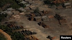 FILE - Piles of wood are seen during "Operation Green Wave" conducted by agents of the Brazilian Institute for the Environment and Renewable Natural Resources, or IBAMA, to combat illegal logging in Apui, in the southern region of the state of Amazonas, Brazil, July 27, 2017.