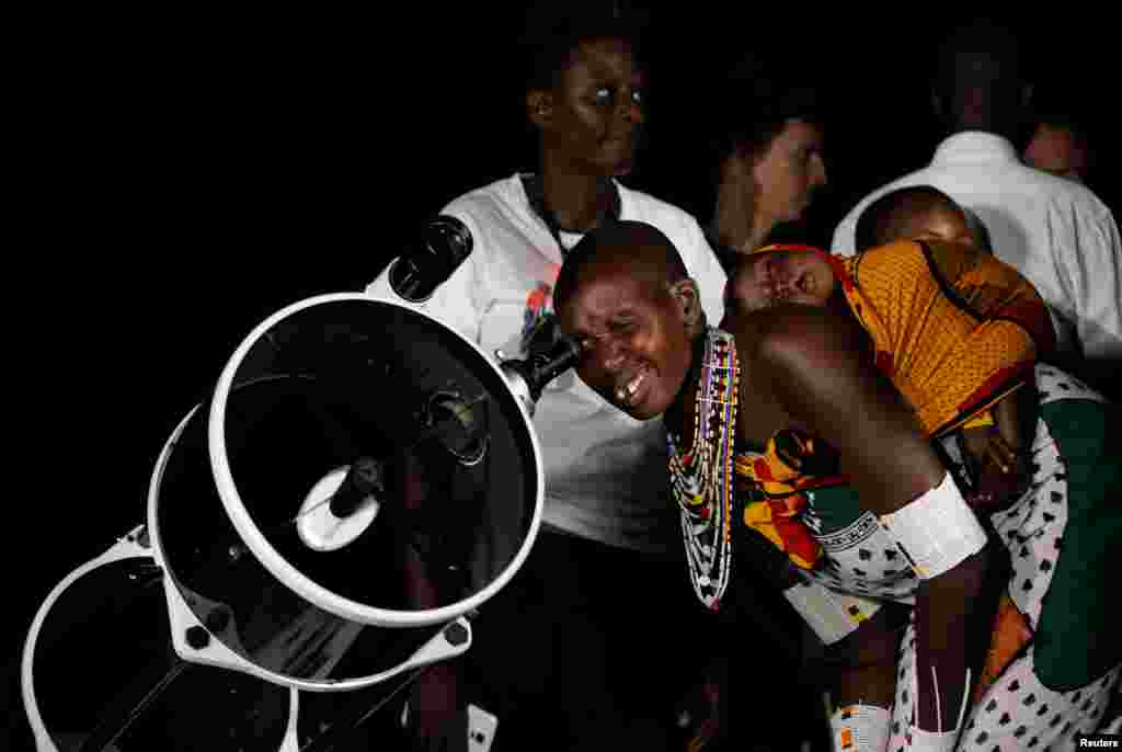 A Maasai tribeswoman uses a telescope to witness the rise of the supermoon in Oloika village in Shompole, Magadi near the Kenya-Tanzanian border, Nov. 14, 2016.