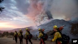 Anggota pemadam kebakaran berjalan dalam antrean saat terjadi kebakaran di Yucaipa, California, Sabtu, 5 September 2020. (Foto: AP)