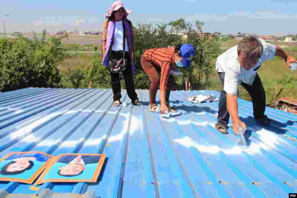 People in Tropeang Lavear display SOS messages on their roofs, which lies in the flight path to Phnom Penh international airport, Cambodia, November 13, 2014. (Nov Povleakhena/VOA Khmer)