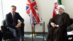 British Prime Minister David Cameron meets with Iranian President Hassan Rouhani at the UN during the 69th Session of the UN General Assembly, Wednesday, Sept. 24, 2014. (AP Photo/Timothy A. Clary, Pool)