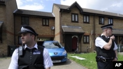 Police officers outside home raided in Stratford, east London, July 5, 2012.