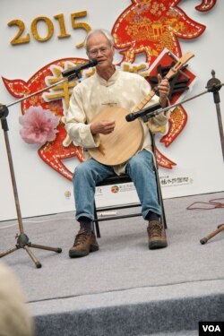 唸歌团长叶文生在台北郊区的林家花园表演月琴弹唱。（美国之音记者方正拍摄）