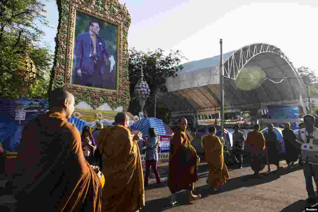 Buddhist monks collect alms as they walk in the anti-government protester encampment near Democracy Monument, Bangkok, Thailand, Jan. 12, 2014.&nbsp;