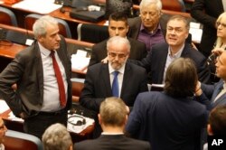 Talat Xhaferi, center, a senior official of the ethnic Albanian Democratic Union for Integrations, stands after being elected as a new speaker in the parliament building in Skopje, Macedonia, April 27, 2017.