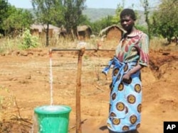 A woman in Mwanza, Malawi, collects tap water. Ecological economist Keven Urama calls for better water management to save rainwater for dry periods.