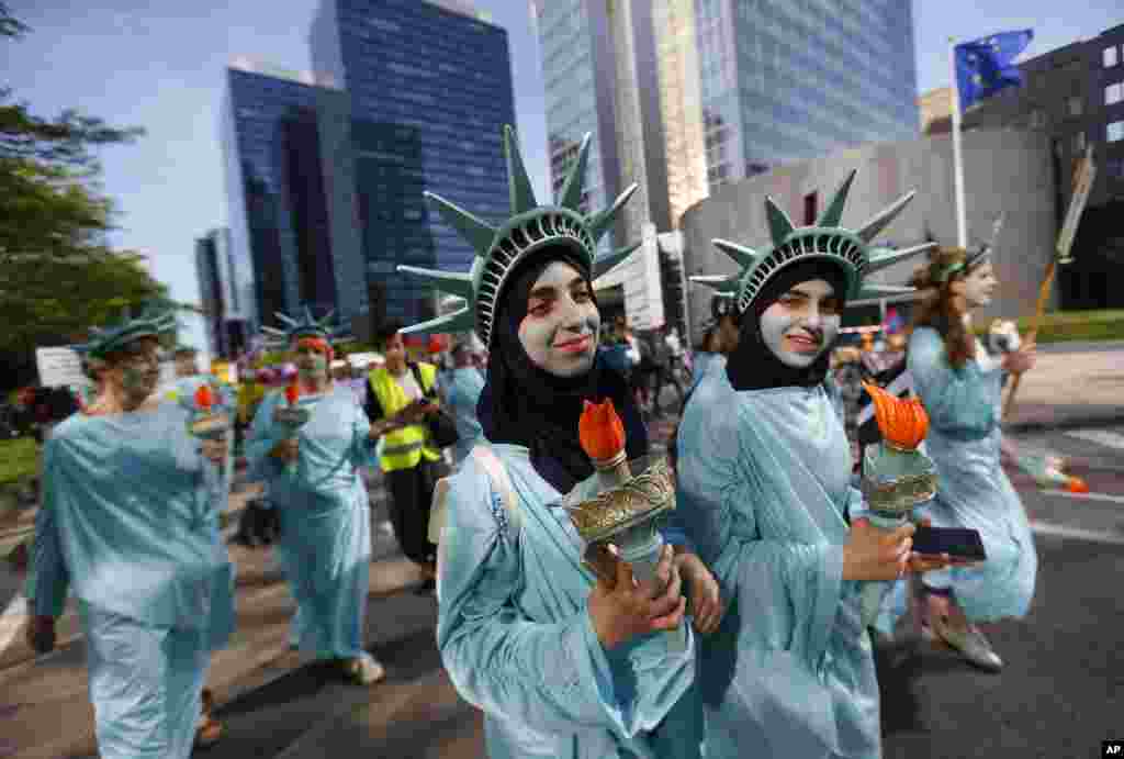 Protesters dressed as the Statue of Liberty march during a demonstration in the center of Brussels, Belgium, ahead of U.S. President Donald Trump's visit and a NATO heads of state summit, which will take place on May 25.